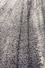 Winter road prepared with gravel for friction in sunny backlight