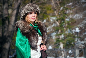 Beautiful blonde woman in winter clothes in the park