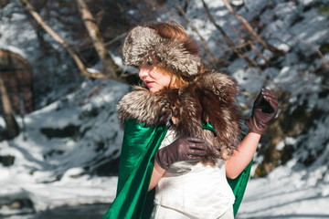 Beautiful blonde woman in winter clothes in the park