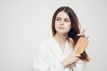 woman combing her hair with a massage comb