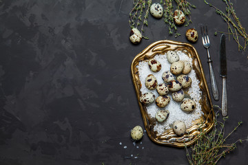 Quail eggs in vintage basket on dark background, top view. Easter