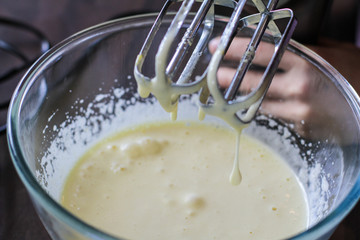 Whisking dough mixture in the glass bowl