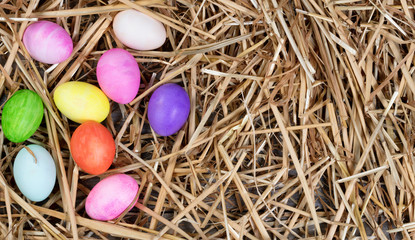 Fototapeta na wymiar Colorful eggs for Easter holiday forming left hand border on straw 
