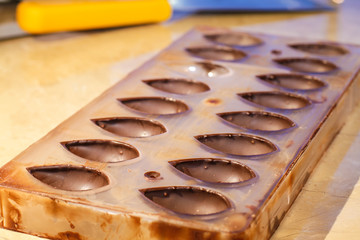 Filling out candy mold form with the chocolate