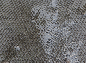 Tire track on a metallic surface covered by snow