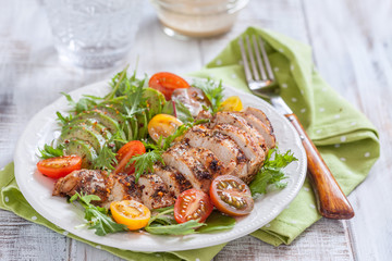 Healthy salad plate with colorful tomatoes, chicken breast and avocado