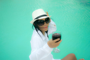 Sexy woman in white shirt posing on the swimming pool