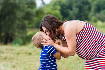 Pregnant woman kissing her son