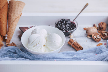 a tray of ice cream, jam and cups of powder on a wooden background