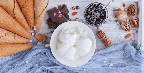 a tray of ice cream, jam and cups of powder on a wooden background