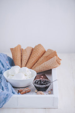 a tray of ice cream, jam and cups of powder on a wooden background