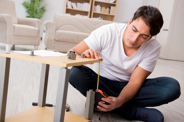 Man assembling shelf at home