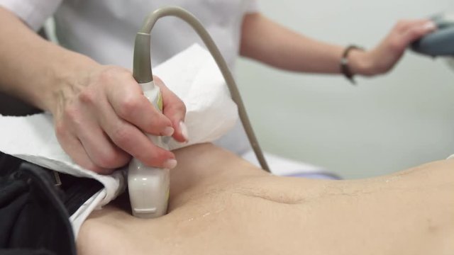 Close up of sonographer hands doing abdominal ultrasound examination with linear ultrasonography probe