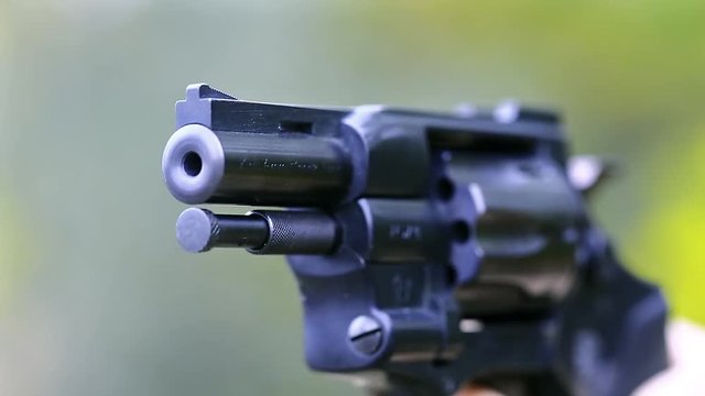Five shots from a revolver. Man shoots a revolver, video with sound. Man cocks and shoots. Man with black gun, raise the cock, cock the gun, close up