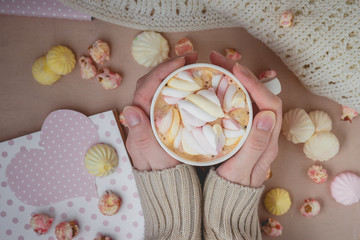 Woman holding cup of hot cacao on wooden background