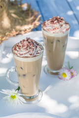 Delicious latte with whipped cream on old wooden table