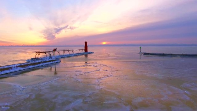 Breathtaking low aerial tour of frozen Lake Michigan harbor Lighthouse.
