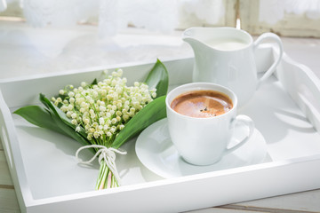 Delicious espresso with flowers on white table