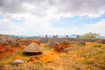 Great Zimbabwe mountain top enclosure with a hut.  Storm clouds gathering. - 133452006