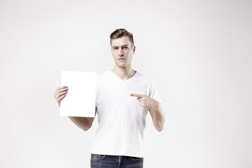 Sexy attractive man model is showing white empty space paper for advert
