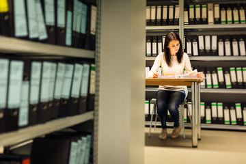 Young Woman Checking Documents In The Archives