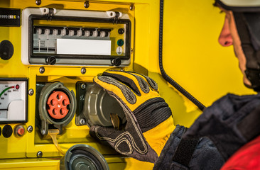 Fototapeta premium HDR - Feuerwehrmann im Einsatz am Einsatzfahrzeug und bedient den Stromgenerator