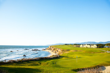 Golf course putting green and cliffs by the pacific ocean bay.  Halfmoon Bay California.  Villas and houses. - 133456469