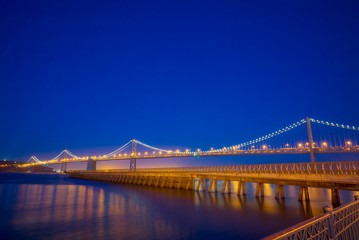 San Francisco Bay Bridge and Pier 14 at night with street lights