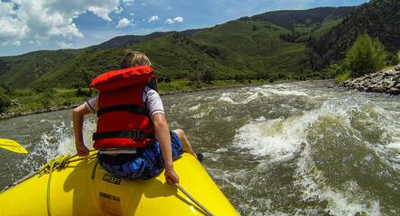 Young Boy rides the Bull during a white water rafting expedition in Glenwood Canyon on the Colorado...