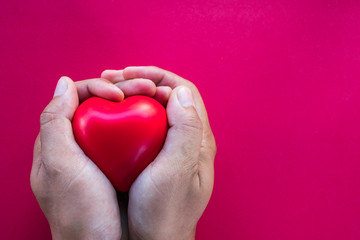man hands giving red heart on coloured background