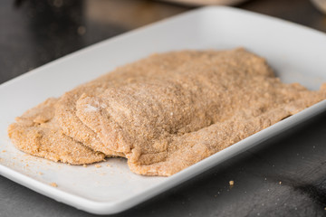 Raw Wiener Schnitzel, thin slices of soft meat dipped in eggs and breadcrumbs