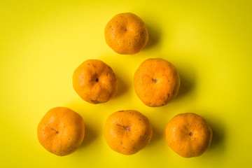Fresh mandarin oranges texture on a yellow background