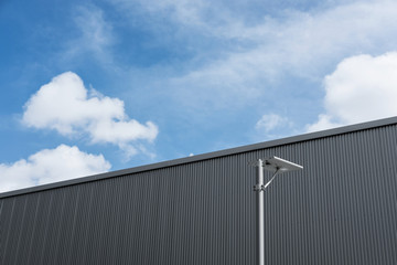 Fototapeta premium Warehouse buildings wall with electricity post, and blue sky with white cloud