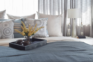 luxury bedroom interior with striped pillows and decorative tea set on bed