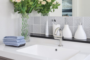 washbasin with faucet and liquid soap bottle at home