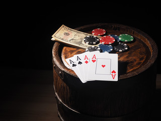 dollars and playing cards on a wooden barrel