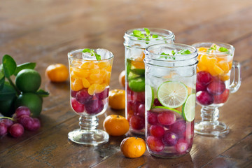 Glass refreshing detox diet drinks of mix fruits on wooden background
