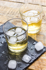 glass of whiskey on wooden background