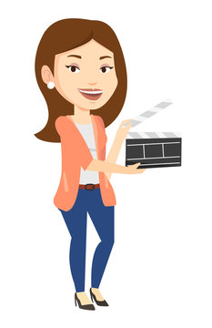 Smiling woman holding an open clapperboard.