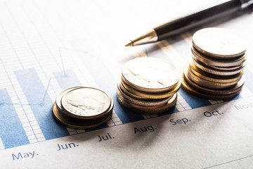 Coin money stacked growing with pen on document graph.financial