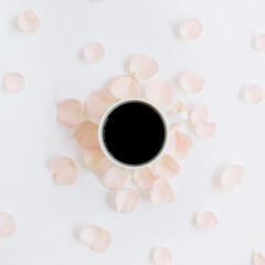 Coffee cup and pink roses petals pattern. Flat lay, top view