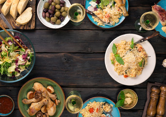 Frame of risotto, salad, appetizer, chicken drumsticks on wooden