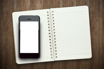 Blank screen  phone on book in wooden background.Photo with copy space.