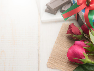 Valentine's day background with chocolate rose flower on wooden