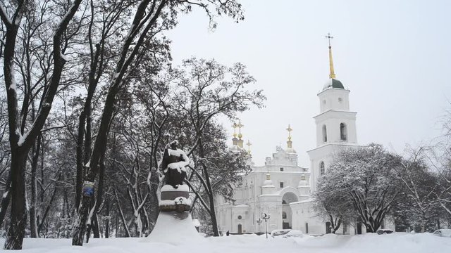 Winter. It is snowing. View of the Cathedral Square in Poltava in Ukraine. On the square are the Cathedral with a bell tower and a monument to the outstanding Ukrainian Hetman Ivan Mazepa.