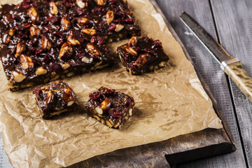 Chocolate and biscuit cake with Brazil nuts and dried cranberries sliced into pieces. Selective focus 