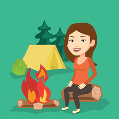 Obraz na płótnie Canvas Woman sitting on log near campfire in the camping.