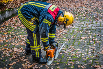 Fototapeta premium HDR - Feuerwehrmann im Einsatz mit Kettensäge