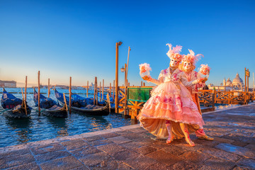 Beroemde carnavalsmaskers tegen gondels in Venetië, Italië
