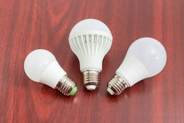 Three different light emitting diode lamp on a wooden surface